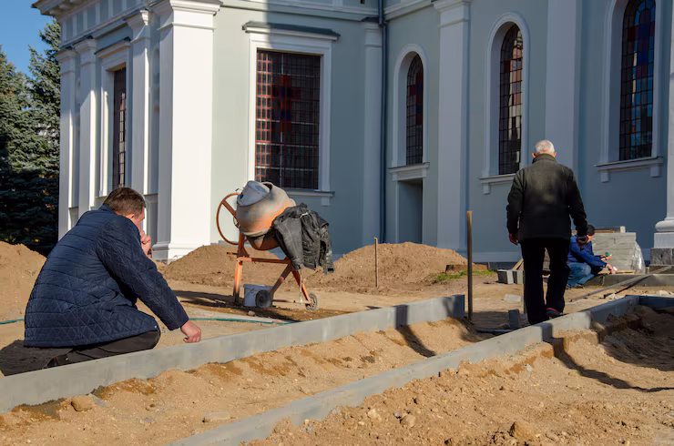 grodno-belarus-october-21-2018-group-builders-engaged-repair-catholic-church-laying-new-sidewalk-chief-engineer-points-problems-work-foundation-repair-pros
